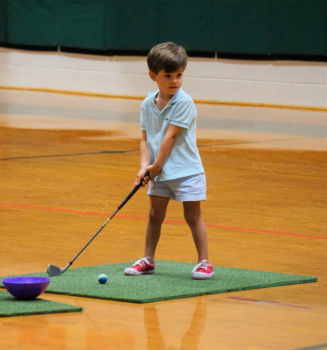 a boy playing mini golf